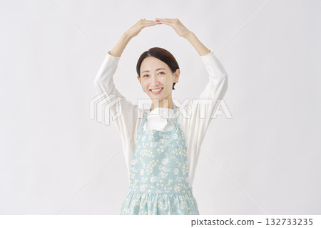 一位身穿圍裙的女子在白色背景上做出畫圈的手勢 132733235