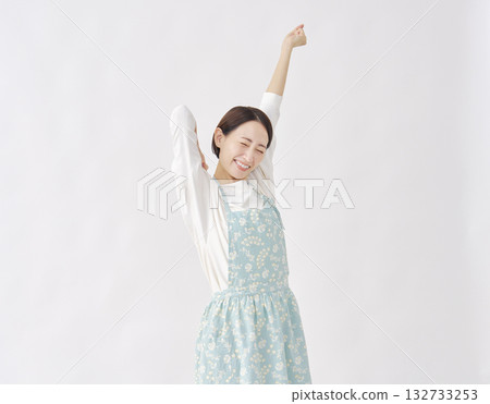 Woman wearing an apron stretching white background Woman wearing an apron stretching white background 132733253