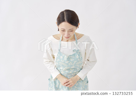 一位身穿圍裙的女子在白色背景下鞠躬 132733255