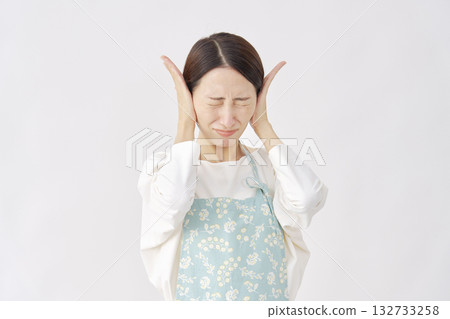 一位女士戴著圍裙遮住耳朵，白色背景 132733258