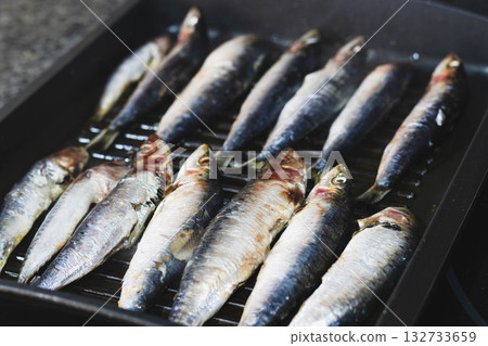 resh sardines cooking on a grill pan 132733659
