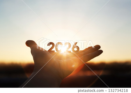 Bright sunlight shining through hands and sunrise background for New Year 2026 132734218