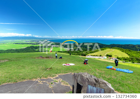 【秋田縣男鹿半島】從乾峰山眺望日本海的壯麗景色。人們正在享受滑翔傘運動。 132734360