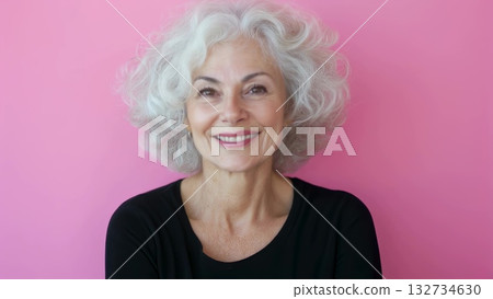 Mature woman with curly gray hair beaming, showing genuine joy and positive energy against pink background Mature woman with curly gray hair beaming, showing genuine joy and positive energy against pink background 132734630