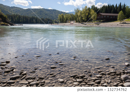 Calm riverfront scene with a pebble-strewn shoreline, clear water. Altai, Russia Calm riverfront scene with a pebble-strewn shoreline, clear water. Altai, Russia 132734762