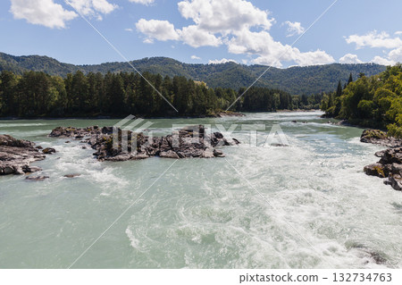 A fast flowing Katun river cuts through rocky outcrops between forested banks A fast flowing Katun river cuts through rocky outcrops between forested banks 132734763