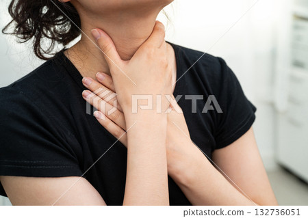 Asian woman touching her neck and throat for thyroid gland problem. Asian woman touching her neck and throat for thyroid gland problem. 132736051