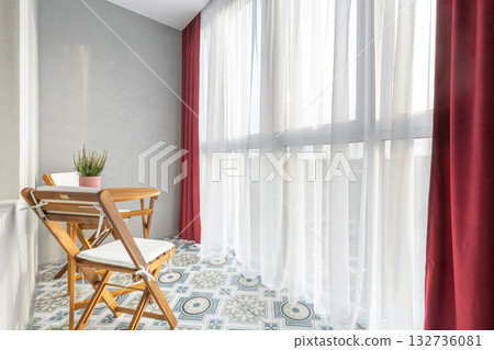 Bright Balcony with Wooden Furniture and Red Curtains 132736081