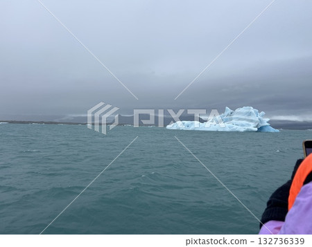 這是從冰島最大的湖泊和冰川湖——傑古沙龍冰河湖上的一艘船上看到的亮藍色冰山。 132736339