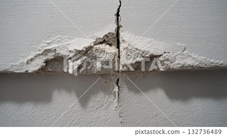 Fiberglass drywall joint tape on wall crack close up showing repair process application 132736489