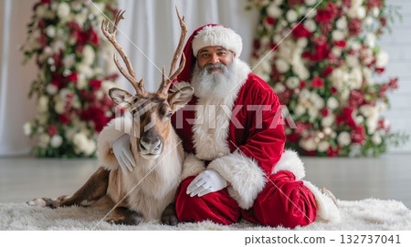 A man in a santa suit sitting next to a reindeer 132737041
