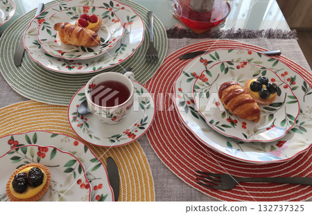 Table setting with bright tableware, berries, and twigs. Dessert on plate. Aesthetics and lifestyle. Home design.  132737325