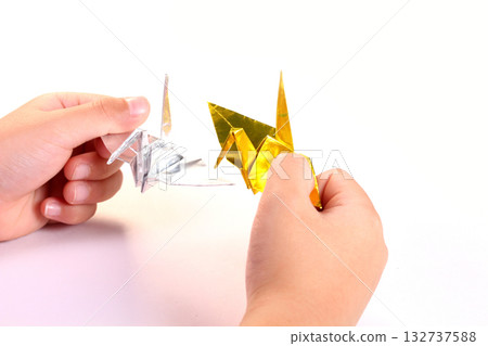 Child's hand holding a folded paper crane Child's hand holding a folded paper crane 132737588