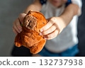 A plush capybara toy held in a child hands. The image reflects Gen Z love for internet-inspired mascots and the aesthetic comfort culture of soft toys. 132737938