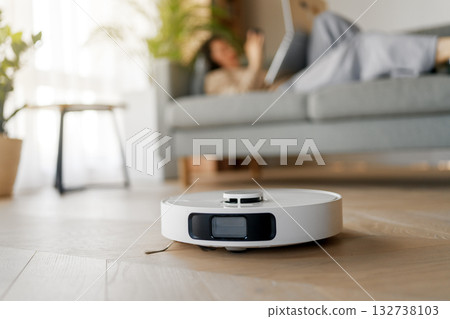 White robotic vacuum cleaner on wooden floor White robotic vacuum cleaner on wooden floor 132738103