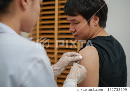 doctor holding syringe and making injection vaccine to patient 132738399