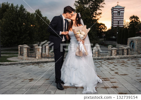 Interracial wedding couple kissing after church ceremony 132739154