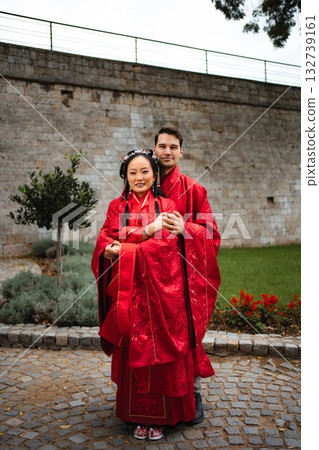 Multicultural couple celebrating wedding day in traditional Chinese attire 132739161