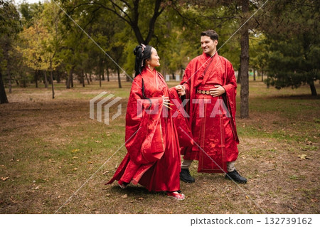 Interracial couple celebrating wedding wearing traditional red Chinese hanfu Interracial couple celebrating wedding wearing traditional red Chinese hanfu 132739162