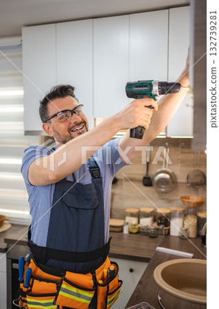 Handyman Using Cordless Drill Installing Kitchen Cabinets 132739281