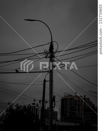 Silhouetted power pole with tangled overhead wires Silhouetted power pole with tangled overhead wires 132739605