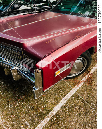 Close up view of a burgundy vintage car parked in parking lot, showcasing its shiny hood, chrome grill, and iconic design elements, evoking sense of nostalgia for classic automobiles. Vintage car 132739693