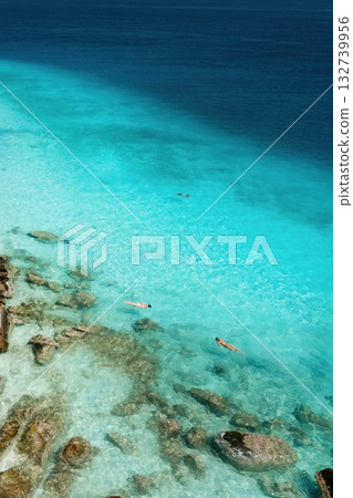 A beautiful tropical beach on the island of Lang Tengah in Malaysia with clear turquoise water and large stones on a sunny day 132739956