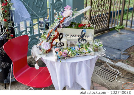 A piano and violin decorated with roses and a decorative table that gives off a musical vibe A piano and violin decorated with roses and a decorative table that gives off a musical vibe 132740088
