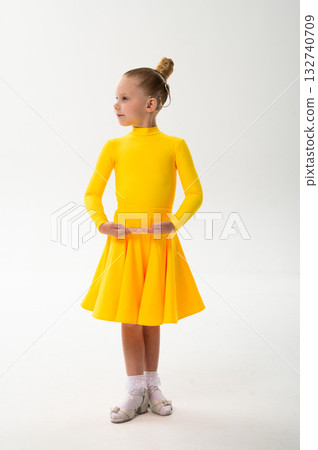 Little girl in yellow dress dancing with cochlear implant. Overcoming hearing loss through rhythm, art, inclusion, and strength of spirit in artistic gymnastics and ballroom dance. Little girl in yellow dress dancing with cochlear implant. Overcoming hearing loss through rhythm, art, inclusion, and strength of spirit in artistic gymnastics and ballroom dance. 132740709