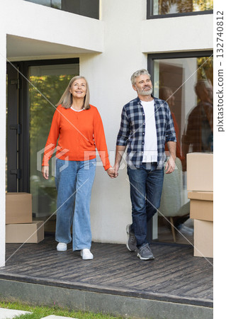Mature couple walking hand in hand and looking happy Mature couple walking hand in hand and looking happy 132740812