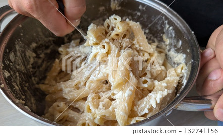 Stepbystep guidance on how to prepare a creamy pasta dish in a mixing bowl with ease 132741156