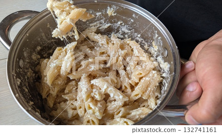 Indulge in a Creamy Pasta Dish cooked in a Pot with Cheese, perfect for any occasion Indulge in a Creamy Pasta Dish cooked in a Pot with Cheese, perfect for any occasion 132741161