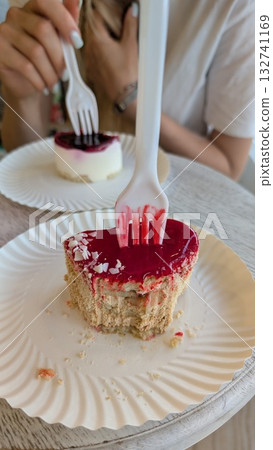Delicious and delightful cake served with forks at a charming cafe setting for enjoyment Delicious and delightful cake served with forks at a charming cafe setting for enjoyment 132741169