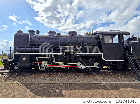 Black metal steam train and rail track in the outdoor history museum Black metal steam train and rail track in the outdoor history museum 132741343