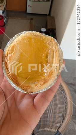 Enjoying a Delicious Egg Tart in Hand, perfect for any occasion and event or gathering Enjoying a Delicious Egg Tart in Hand, perfect for any occasion and event or gathering 132741354