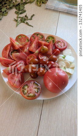 Delicious and Fresh Colorful Tomatoes Resting on a Beautiful Plate Accompanied by Mozzarella Delicious and Fresh Colorful Tomatoes Resting on a Beautiful Plate Accompanied by Mozzarella 132741405
