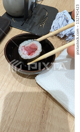 A Delicious Sushi Roll served with Soy Sauce, perfect for any dining experience or occasion 132741423
