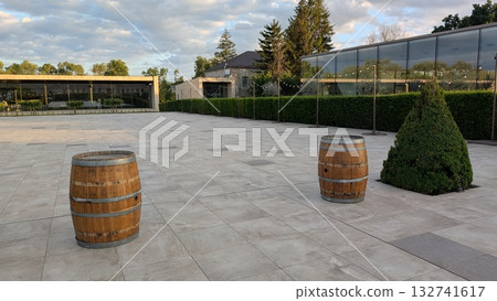 A stylish outdoor area with wine barrels and elegant landscaping for social events and relaxation A stylish outdoor area with wine barrels and elegant landscaping for social events and relaxation 132741617