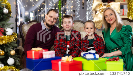 Family with mom and dad celebrates Christmas at home Family with mom and dad celebrates Christmas at home 132741740