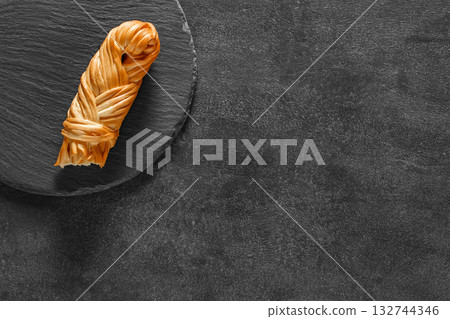 suluguni pigtail cheese on grey table, top view suluguni pigtail cheese on grey table, top view 132744346