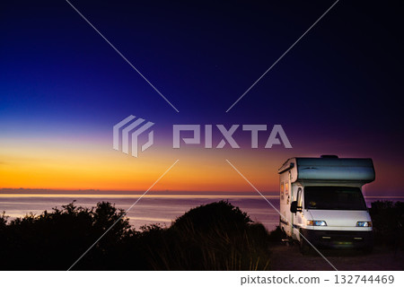 Camper vehicle on seashore at sunrise dawn Camper vehicle on seashore at sunrise dawn 132744469