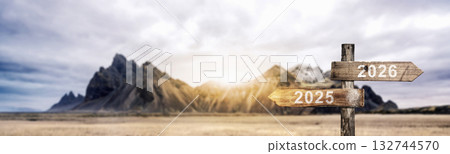 Wooden signpost pointing in different directions with the years 2025 and 2026 with a mountain landscape background. Happy New Year concept or Celebration Wooden signpost pointing in different directions with the years 2025 and 2026 with a mountain landscape background. Happy New Year concept or Celebration 132744570