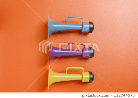 Plastic horn on a red background. Concept of a party or a holiday celebration 132744575