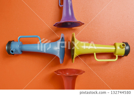Plastic horn on a red background. Concept of a party or a holiday celebration 132744580