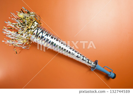 Party horn on a red background. Concept of a party or a holiday celebration Party horn on a red background. Concept of a party or a holiday celebration 132744589
