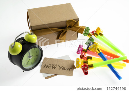 Greeting card of Happy New Year with an alarm clock, a gift box, and party blowers. Mockup or Copy space. Happy New Year concept or Celebration Greeting card of Happy New Year with an alarm clock, a gift box, and party blowers. Mockup or Copy space. Happy New Year concept or Celebration 132744598