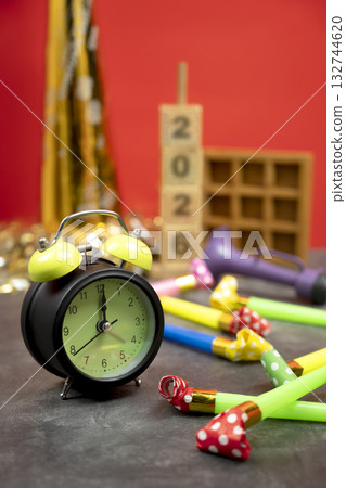 Stack of wooden cubes with the number 2026 with an alarm clock, plastic horn, and party blowers. Happy New Year concept or Celebration 132744620