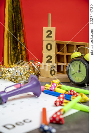 Stack of wooden cubes with the number 2026 with an alarm clock, plastic horn, and party blowers. Happy New Year concept or Celebration Stack of wooden cubes with the number 2026 with an alarm clock, plastic horn, and party blowers. Happy New Year concept or Celebration 132744729