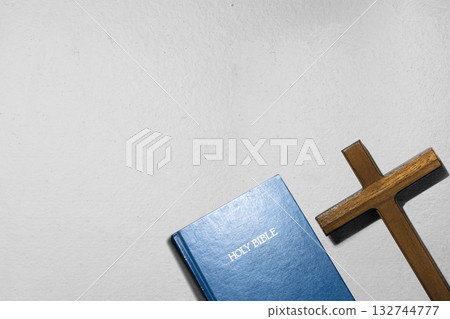 Blue book of the Holy bible and a Christian cross on the table. Symbol of faith in God. Concept of Spirituality, Christianity, religion, faith, Jesus, or belief 132744777