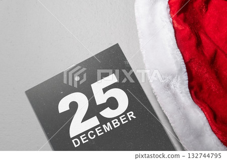 Santa hat and calendar showing 25 December on a white background. Mockup or Copy space. Holiday greetings or winter themes. Concept of the Merry Christmas celebration 132744795